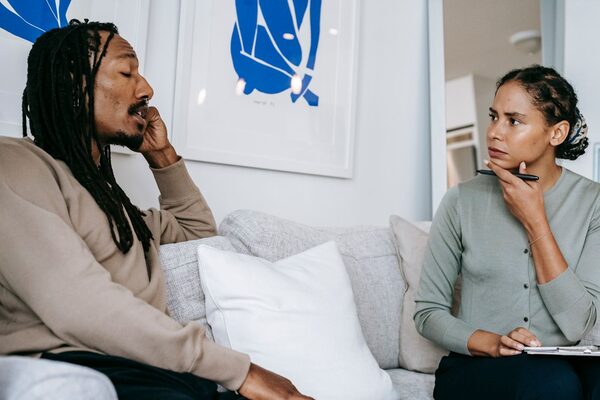 A counselor listening to a man on a couch