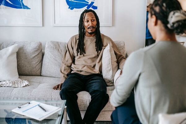 A man talking with a therapist in a living room
